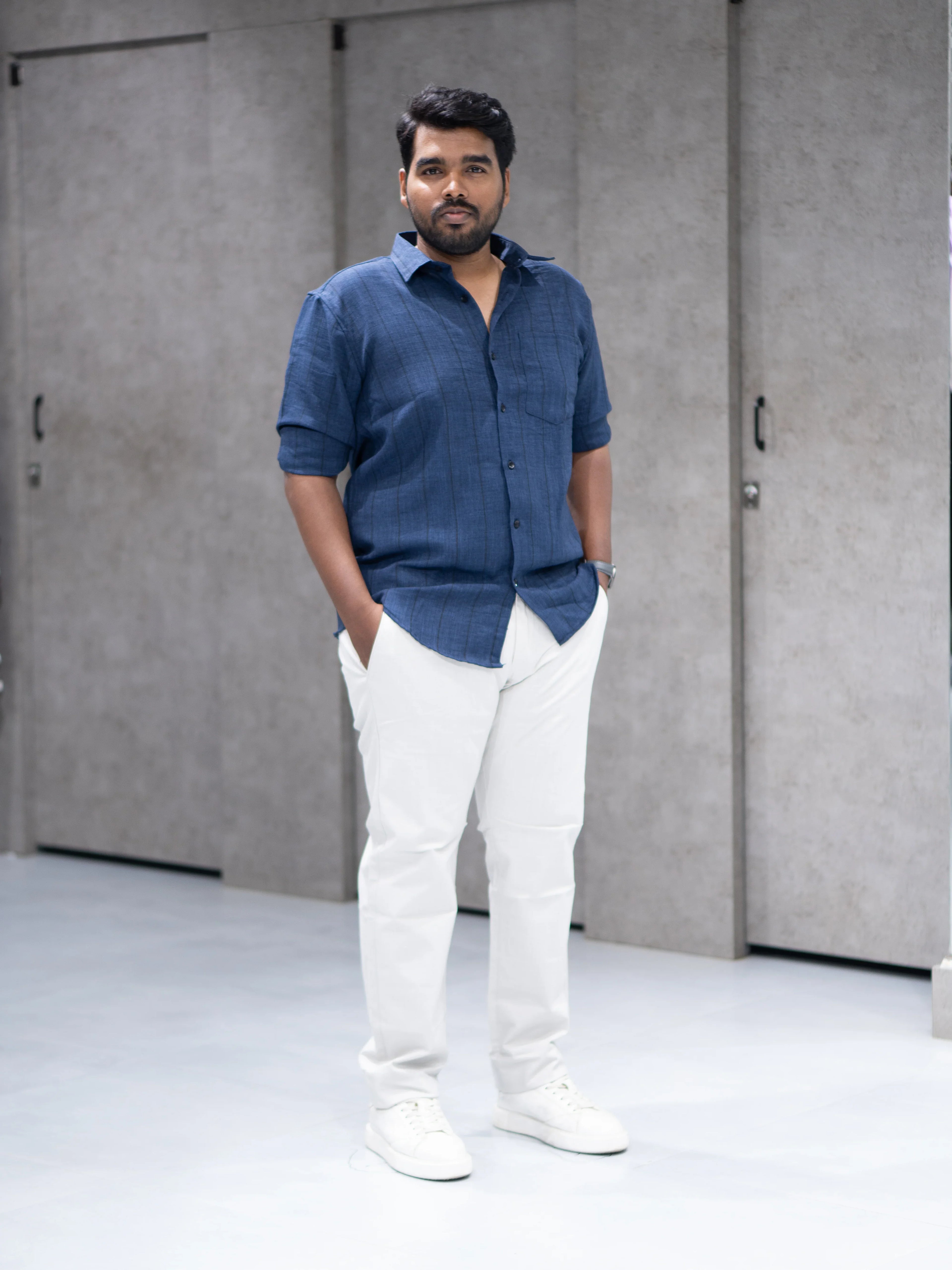 Man in navy blue striped shirt and white pants, modern casual office wear for everyday style