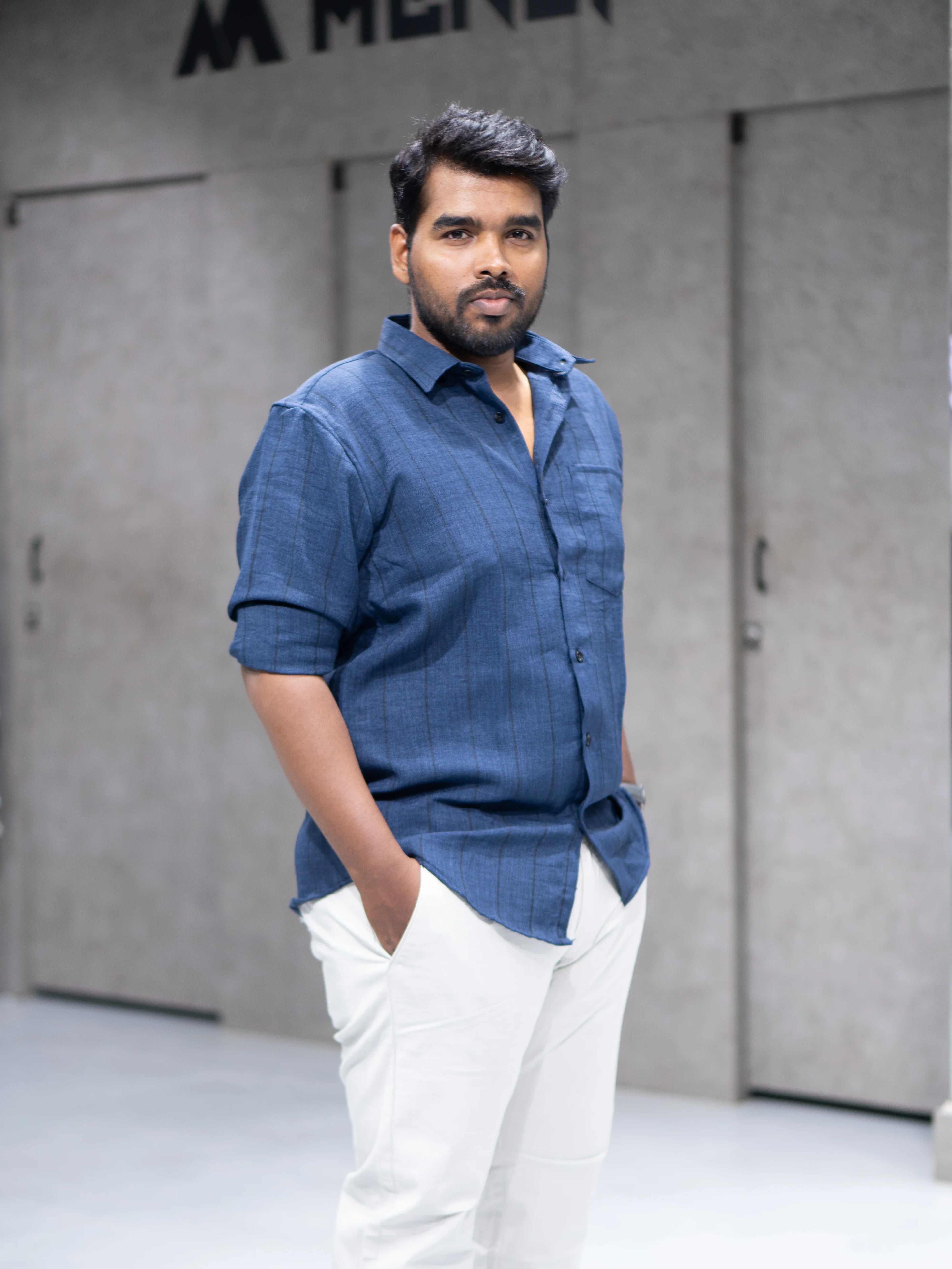 Man in blue striped shirt and white pants, modern formalwear for office or interviews