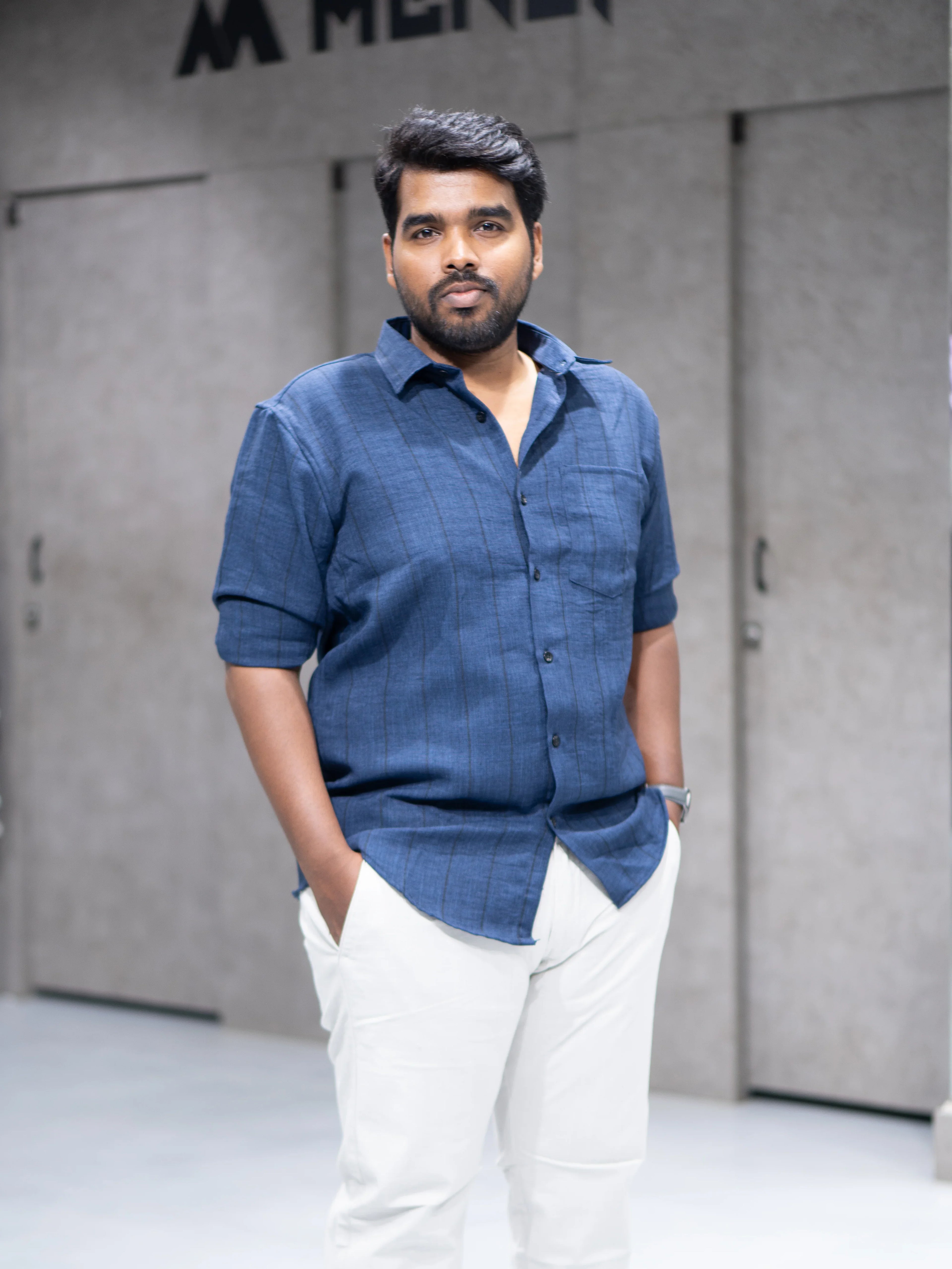 Man in blue striped shirt and white pants, modern casual formalwear for office or interviews