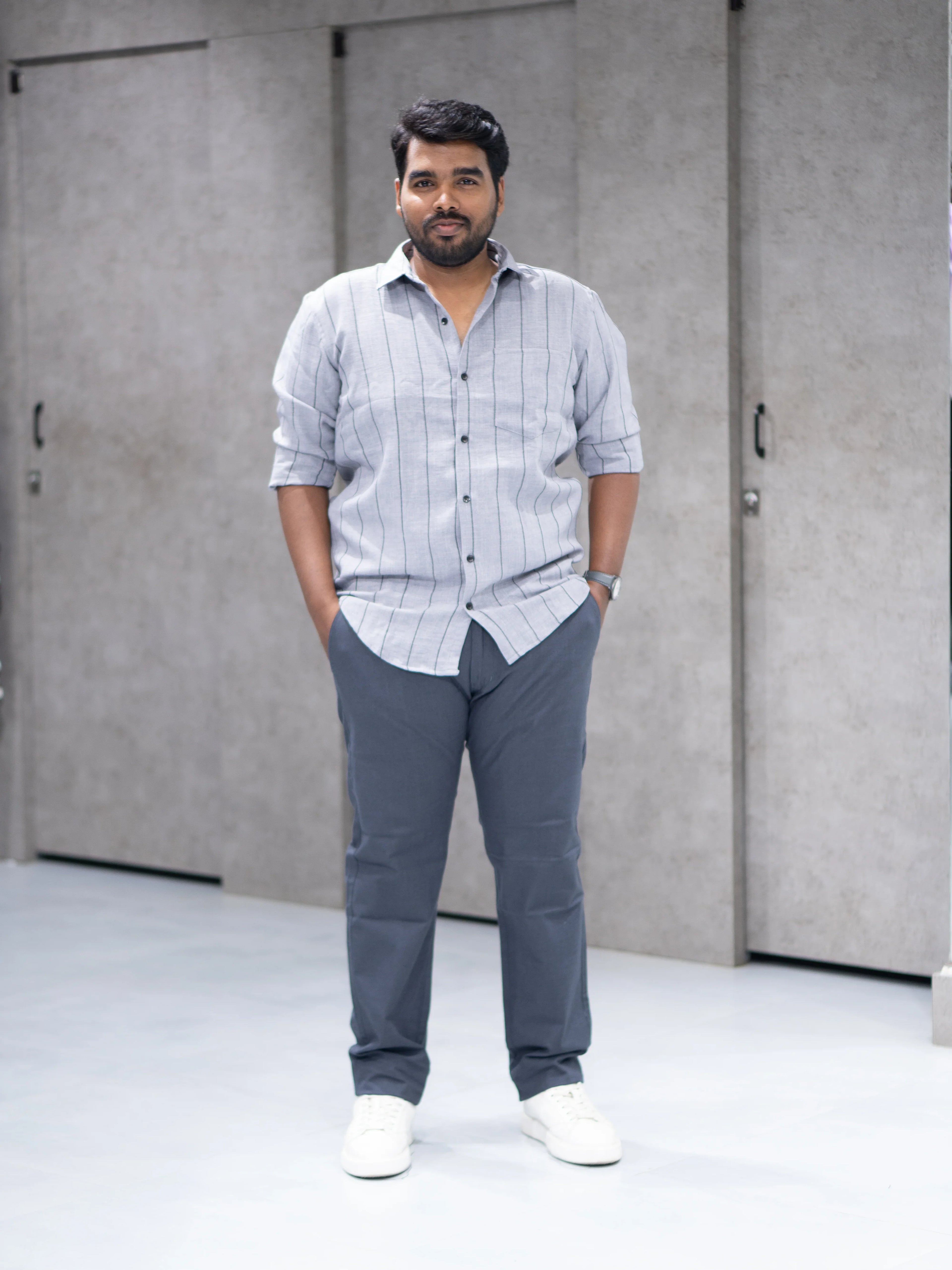 Man in grey striped shirt and tailored trousers, modern smart casual outfit for office or interviews