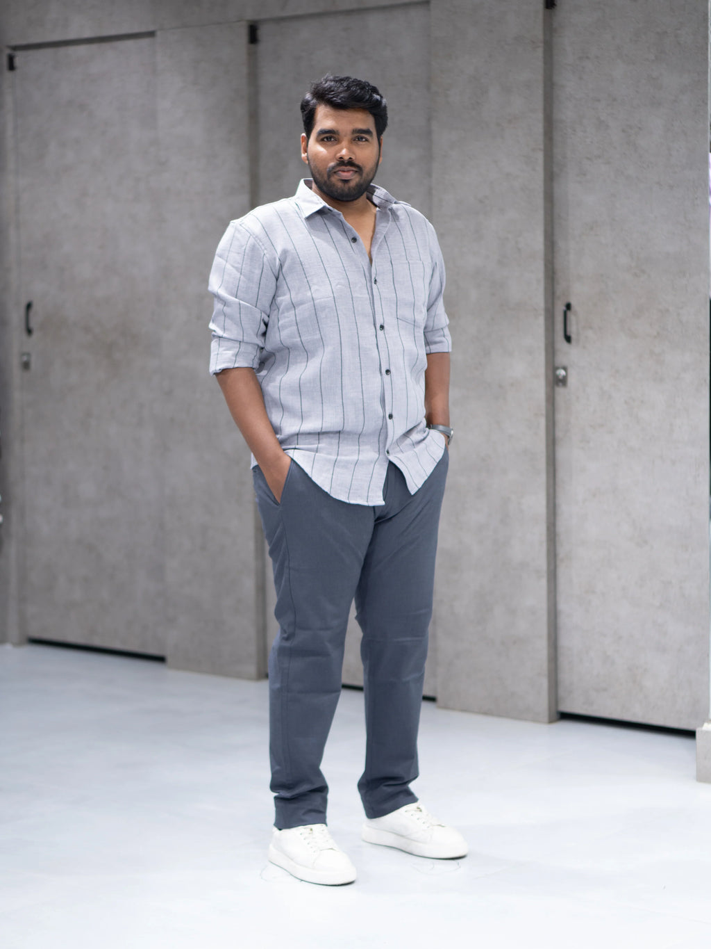 Man in gray striped shirt and tailored pants, modern office wear for everyday success