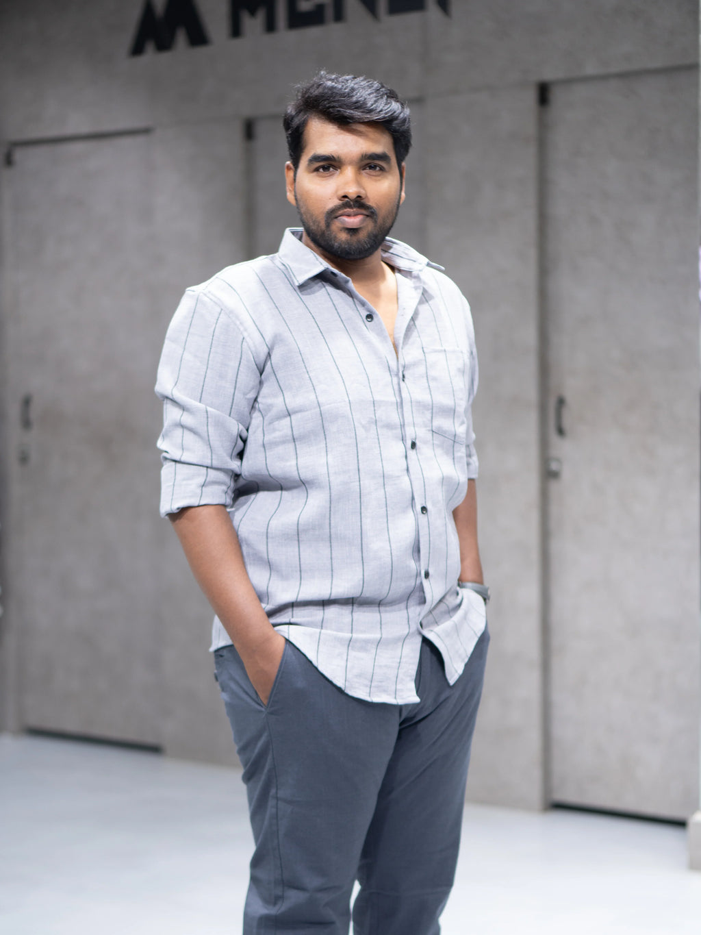 Man in light gray striped shirt and gray trousers, modern formalwear for office or interviews