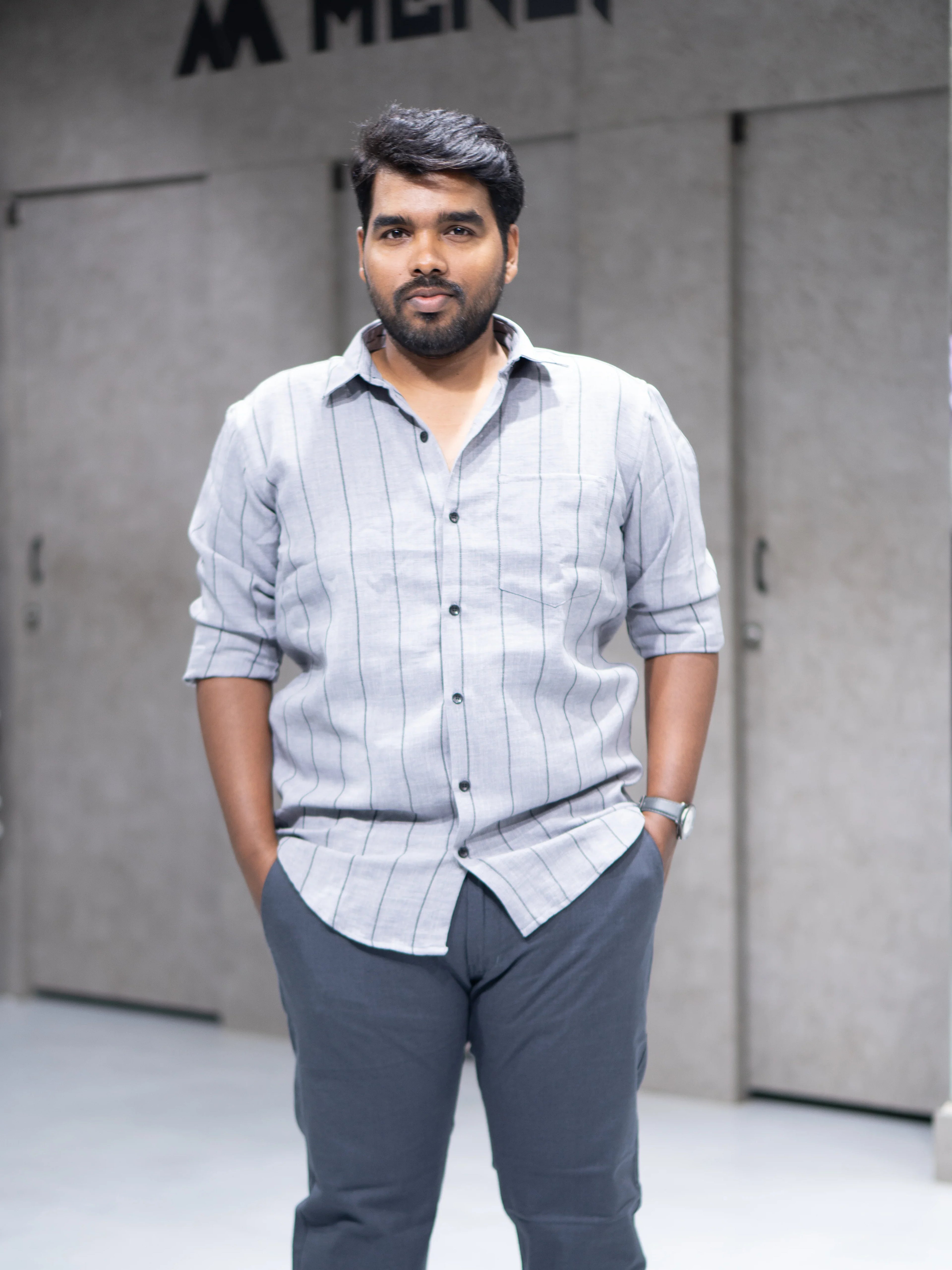 Man in gray striped button-down shirt and tailored trousers, modern office wear for professional success