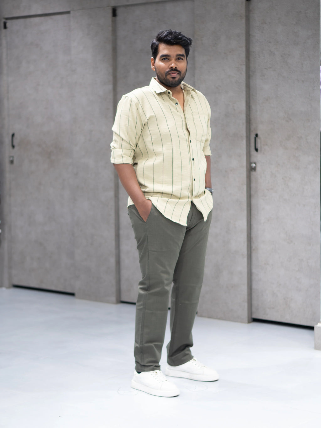 Man in striped button-down shirt and olive pants, modern casual office wear