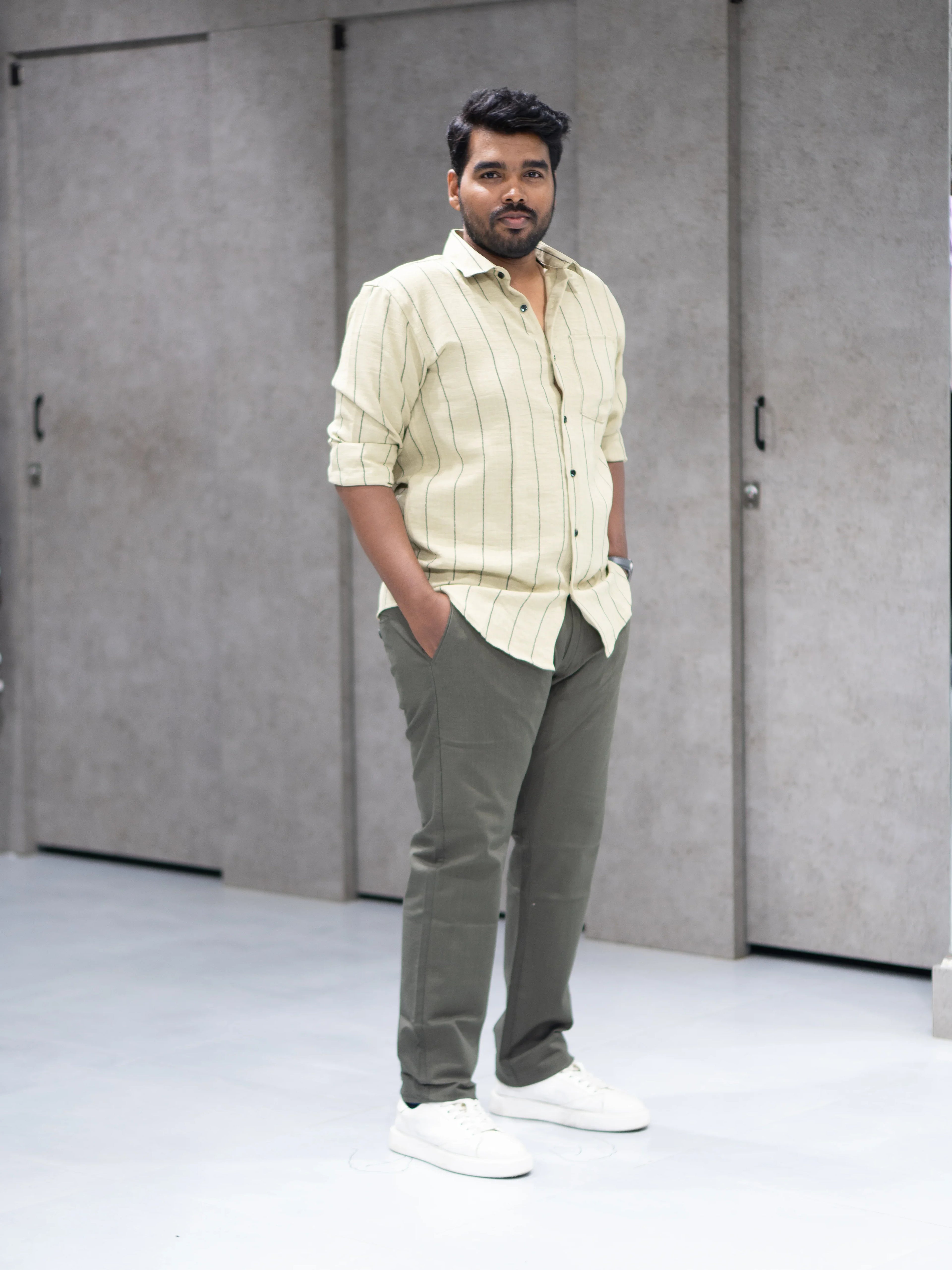 Man in striped button-down shirt and olive pants, modern casual office wear