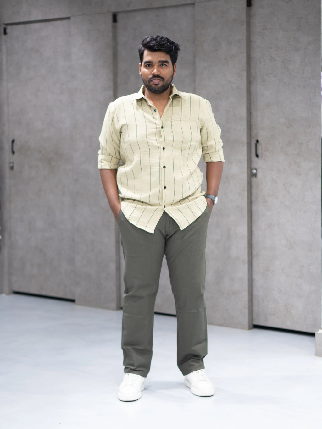 Man in beige striped shirt and olive pants, modern smart casual outfit for office or everyday wear