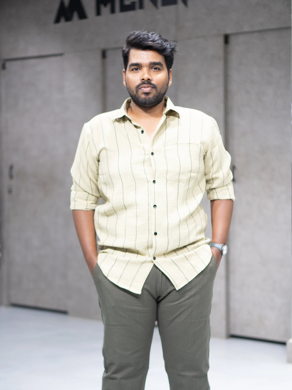 Man wearing striped button-up shirt and olive pants for modern formalwear