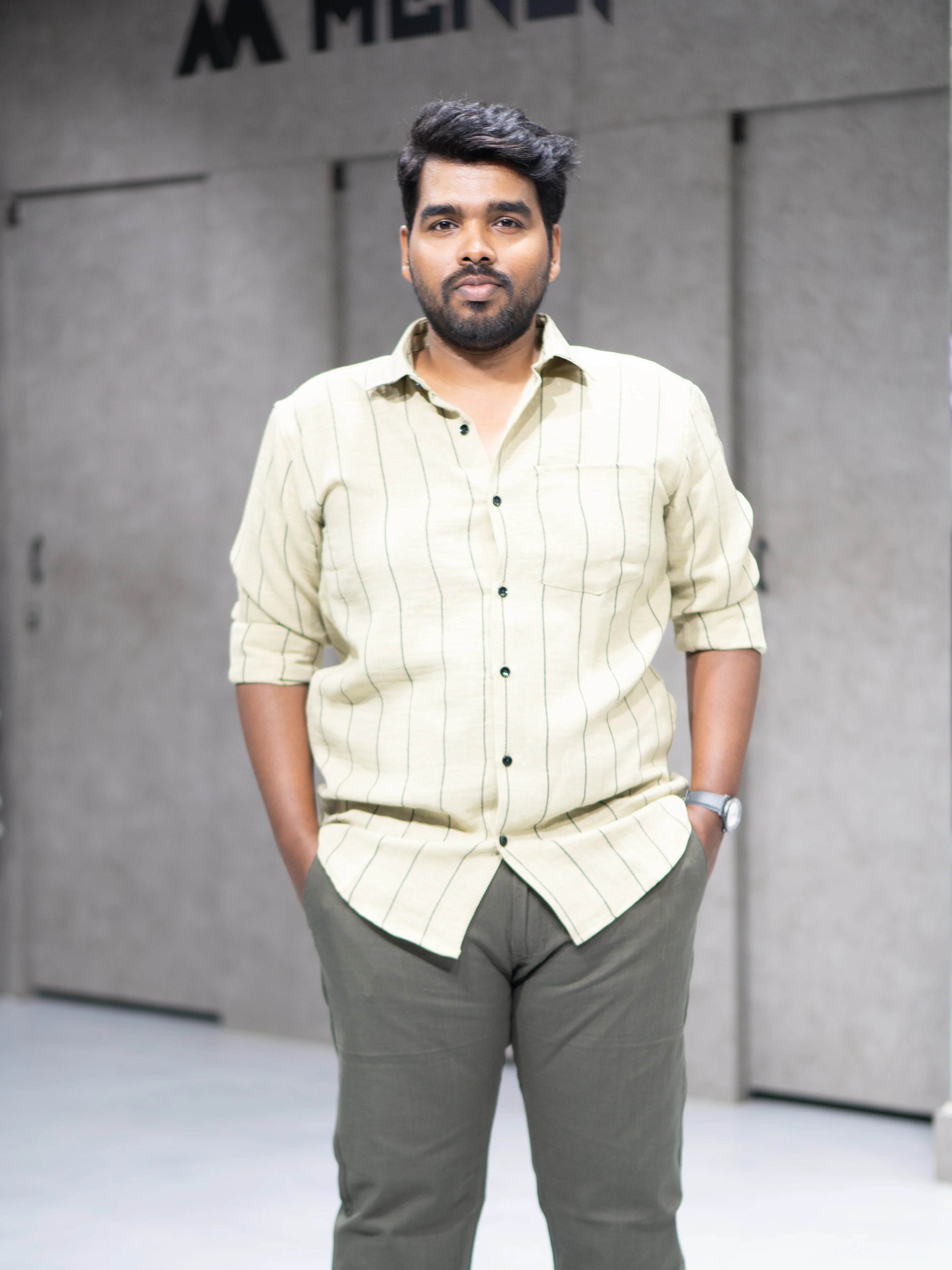 Man wearing striped button-up shirt and olive pants for modern formalwear